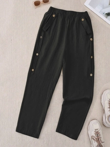 Flat lay of casual black wide-leg trousers with button details and elastic waist