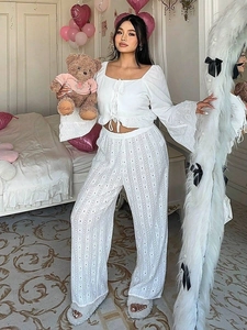 Close-up of white two-piece cotton eyelet embroidery set with ruffled top and wide pants