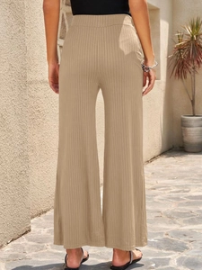 Macro shot of khaki ribbed wide-leg trousers showing vertical knit texture and elastic waist