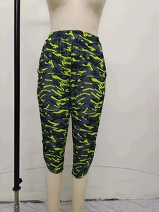 Detail der gelben Camouflage-Caprihose mit elastischem Bund und seitlichen Knöpfen