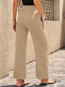 Outdoor shot of high-waisted khaki ribbed wide-leg pants on a model with a black top