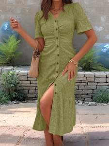 Detail of olive green eyelet embroidered dress with V-neck and buttons in outdoor garden