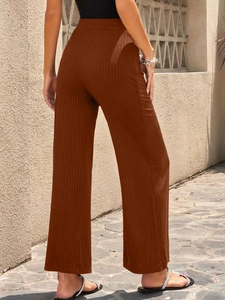 Detail view of brown wide-leg pants with vertical ribbed texture and high waist design