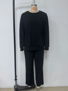 Close-up of black lounge set featuring pleated front sweatshirt and matching wide-leg pants