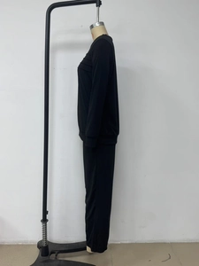 Detail of black lounge set showing ruched waist design on long sleeve top and wide leg pants