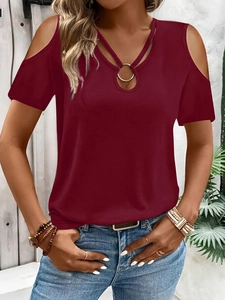Detalle de camiseta burdeos con hombros descubiertos, tiras en V y anillo metálico