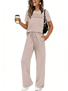 Detail of short sleeve lounge set featuring pleated top and drawstring wide leg trousers