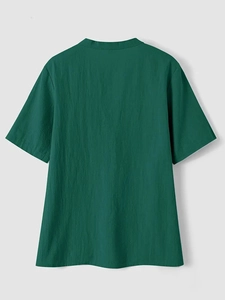 Detail view of dark green cotton linen shirt back with stand collar and neat stitching