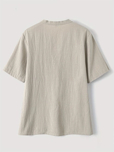 Detail of the natural linen texture and minimalist back stitching on light beige short sleeve shirt