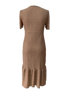 Detailed view of intricate lace embroidery and hollow floral textures on a tan dress