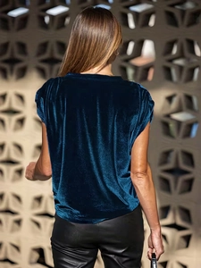 Détail de la texture en velours sarcelle doux et coupe ample de ce haut chic