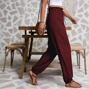Détail du pantalon bordeaux à taille haute avec taille élastique volantée et cordon