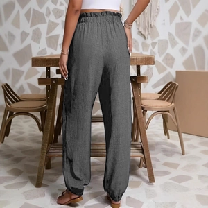 Détail de la taille haute élastique et du tissu gris foncé texturé du pantalon décontracté