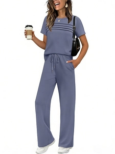 Detail of greyish-blue short sleeve tee with pleat design and drawstring wide leg trousers