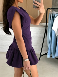 Detailed view of dark purple sleeveless dress with ruffle trim and tiered flounce hemline