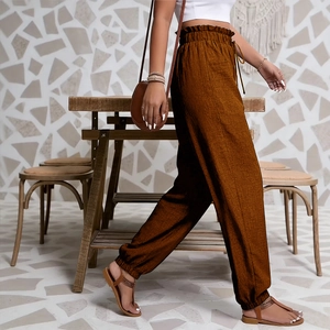 Détail de la taille haute élastique avec cordon de serrage sur le pantalon marron caramel