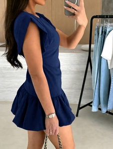Detail of dark blue sleeveless dress featuring ruffle shoulder pads and pleated mini hem