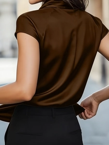 Detail of soft silk-like satin fabric and elegant back drape of a dark brown short-sleeve top