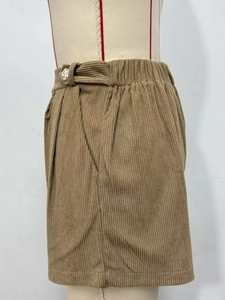 Detail view of brown corduroy shorts featuring waist buckle and side pocket design