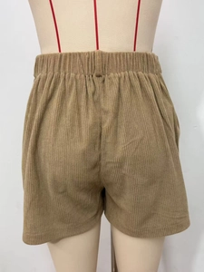 Detailed view of brown corduroy texture and elastic high waistband on casual women shorts
