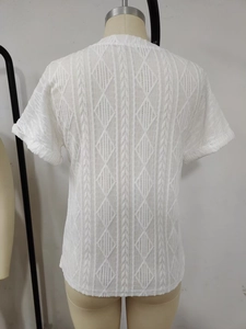 Close-up of white T-shirt featuring intricate geometric diamond and vertical stripe textures