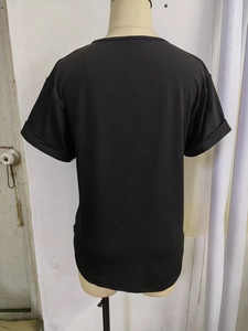 Detailopname van zwart T-shirt met korte mouwen, omgeslagen manchetten en zachte breistructuur