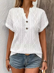 Detail of white V-neck T-shirt showing geometric knit texture and wooden buttons