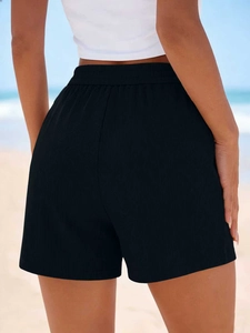 Vue arrière du short de sport noir côtelé à taille haute sur fond de plage