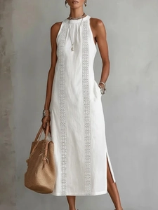 Detail of white sleeveless maxi dress featuring wavy embroidery and high side slits