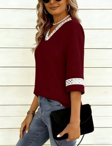 Detail of V-neckline with delicate white lace trim on a burgundy short sleeve T-shirt