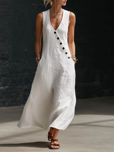 Close-up of white cotton linen maxi dress featuring diagonal black buttons and V-neckline