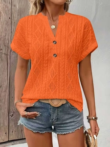 Detailed close-up of orange V-neck knitted t-shirt with diamond texture and buttons