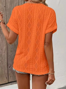 Close-up of orange short sleeve knit top with diamond hollow out and cable knit details