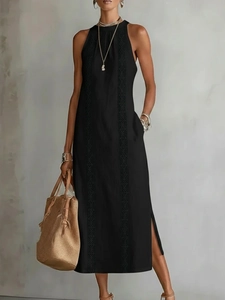 Detail of a black halter maxi dress showing vertical geometric embroidery and side slit