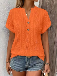 Detail of orange V-neck knit top with diamond eyelet texture and decorative buttons