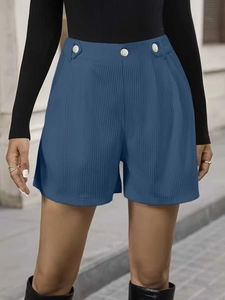 Detail of high-waisted corduroy shorts in dark blue with silver decorative buttons