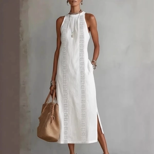 Detail of white halter maxi dress showing geometric embroidery and cotton linen texture