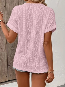 Detail of pink knit T-shirt featuring delicate diamond hollow weave and rolled sleeves