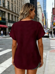 Detail van bordeauxrood T-shirt met omgeslagen mouwen en een ronde achterzoom design