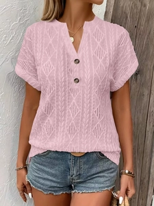 Detail of pink knit T-shirt featuring V-neckline with brown buttons and diamond texture