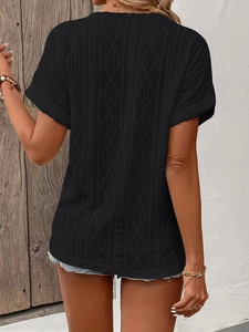 Detail of black hollow-out knit texture and geometric patterns on a casual V-neck t-shirt