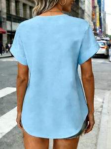 Lichtblauw dames t-shirt met korte mouwen, knoopdetail en een ronde zoom afwerking