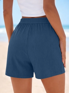 Détail du short côtelé bleu marine avec taille haute élastique sur fond de plage