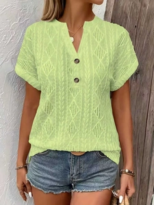 Detail of lime green V-neck knitted top showing textured knit pattern and buttons