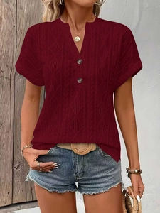 Detail of burgundy V-neck knit T-shirt featuring decorative buttons and cable texture