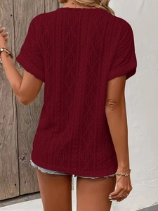 Detail view of burgundy short sleeve knit top showing hollow diamond pattern and texture