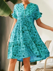 Détail de robe florale bleu clair avec col en V à boutons et manches volantées