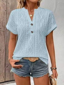 Detailed view of light blue knitted shirt with V-neck buttons and diamond texture