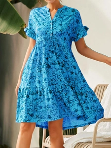 Détail du col en V avec boutons et imprimé fleuri sur cette robe d'été bleue