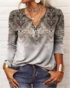 Detail of bohemian paisley print on a women long sleeve top with small neck buttons